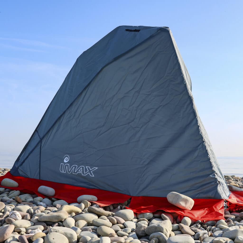 grey and orange beach fishing tent on pebble beach