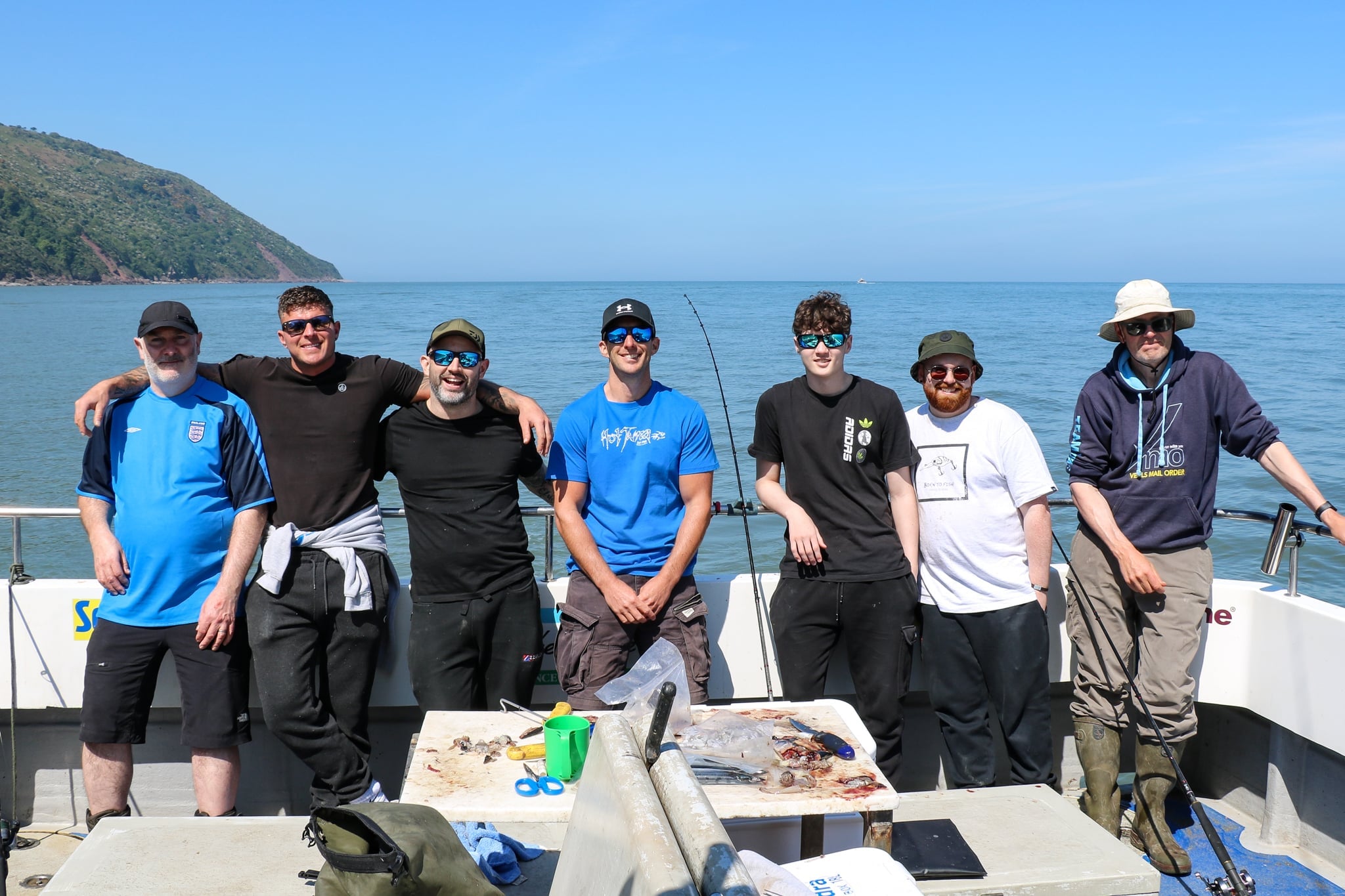 anglers stood in a line at the back of a fishing boat
