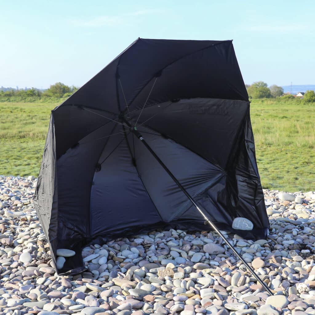 fishing brolly set up on pebble beach
