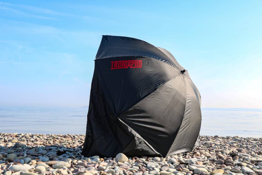 fishing brolly with wings on pebble beach in sunshine